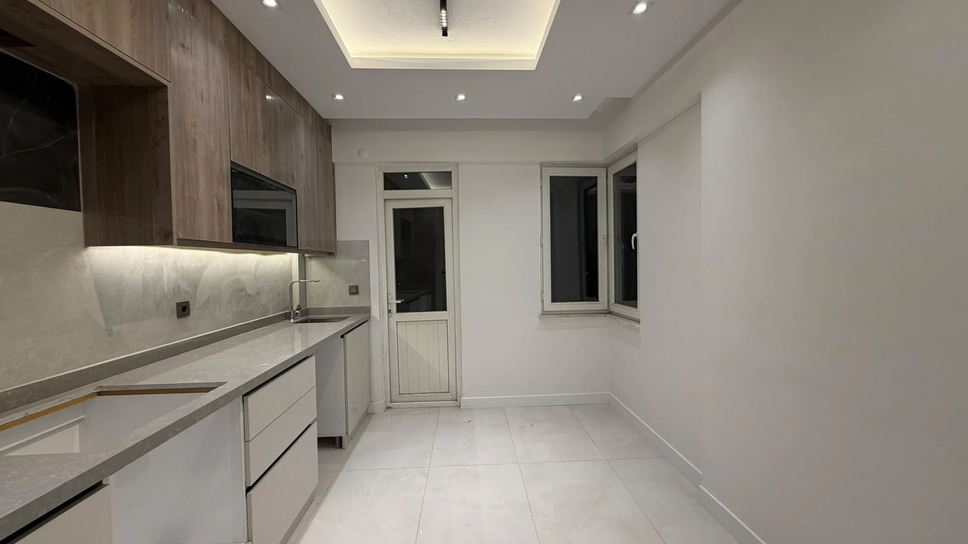 Kitchen countertop, cabinets and the view towards the window