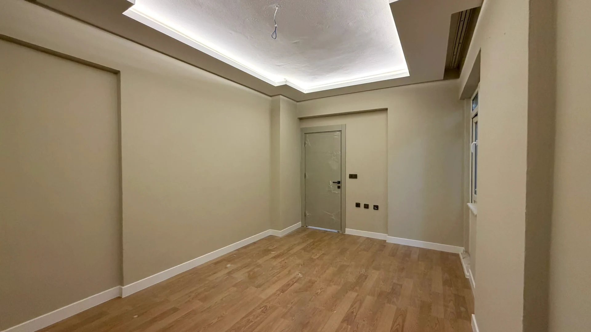 Room with renovated flooring and ceiling lighting